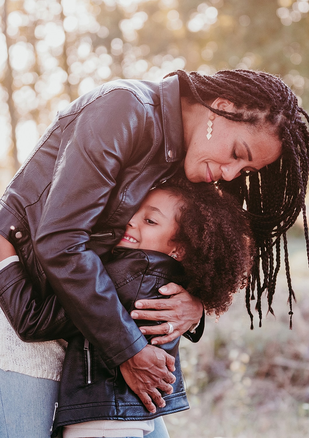 Mother and daughter sharing a loving embrace outdoors.