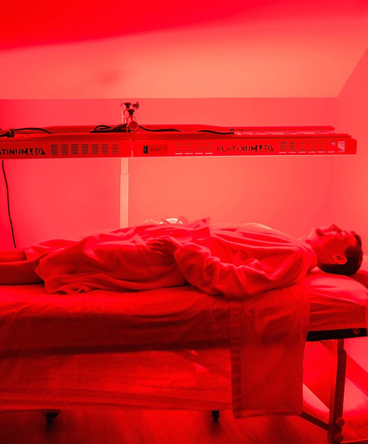 Person relaxing under red light therapy.