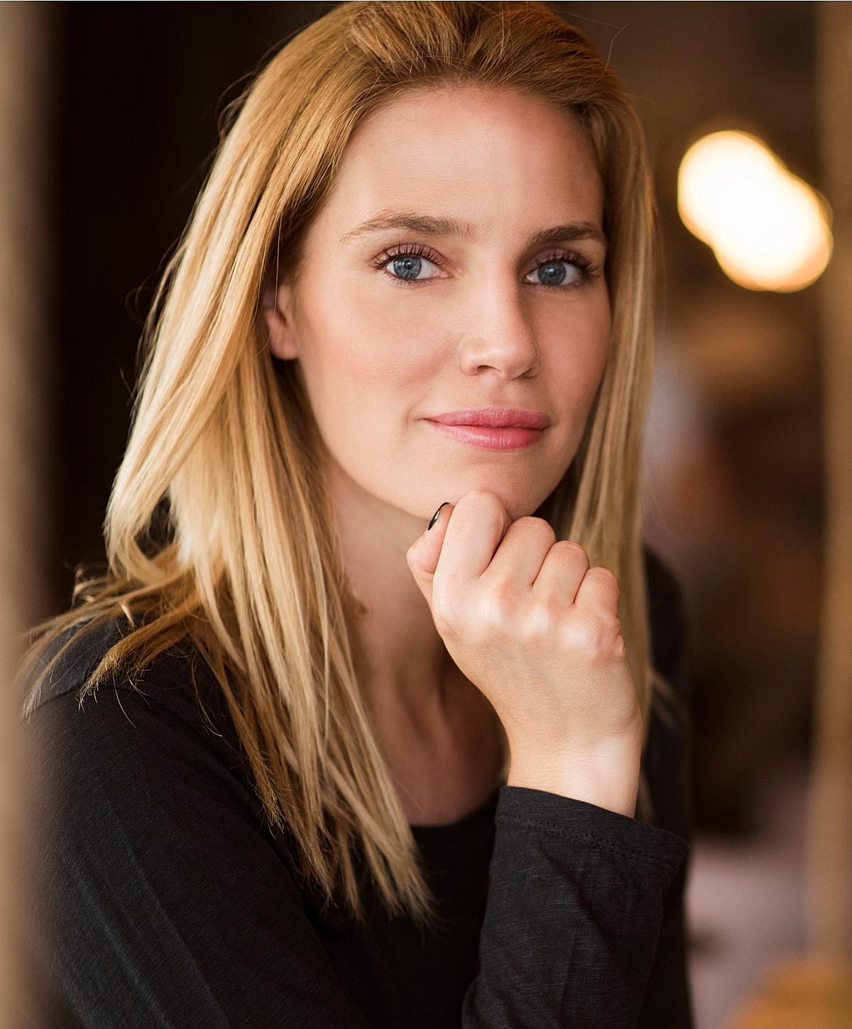 microneedling patient model with long blonde hair resting chin on hand