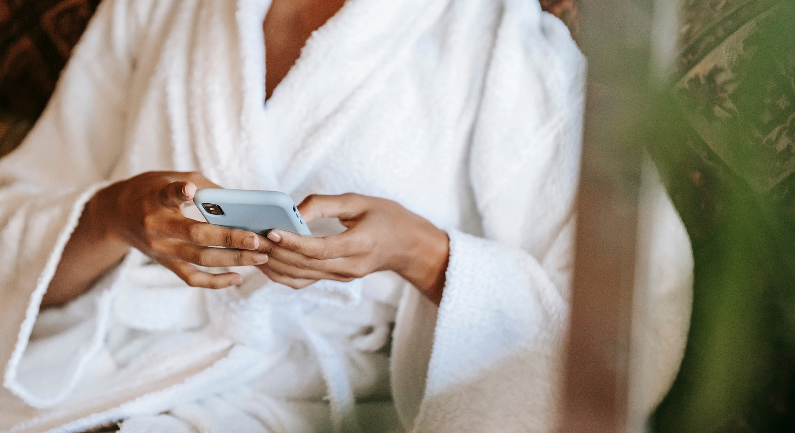Person in a bathrobe using a smartphone.