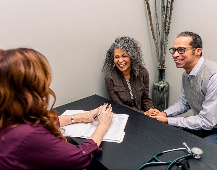 Couple enjoying conversation with healthcare professional.