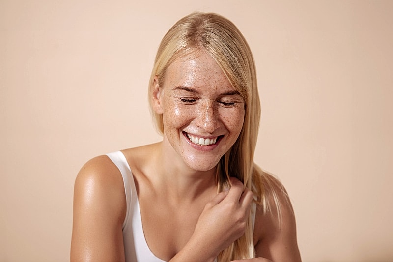 Smiling woman with blonde hair and freckles.