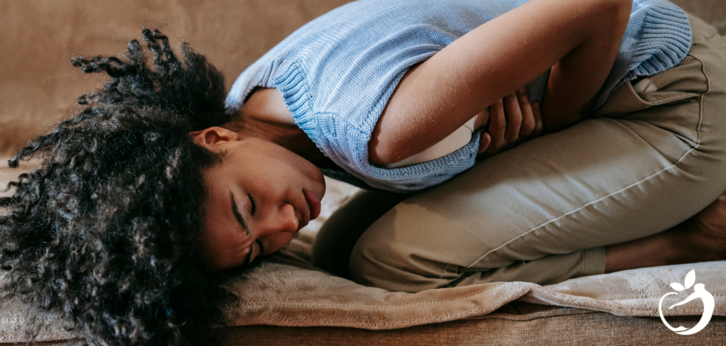 woman doubled-over, holding her stomach