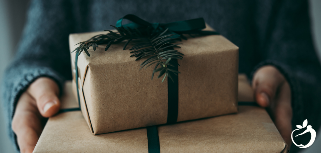 person holding two brown paper wrapped gifts