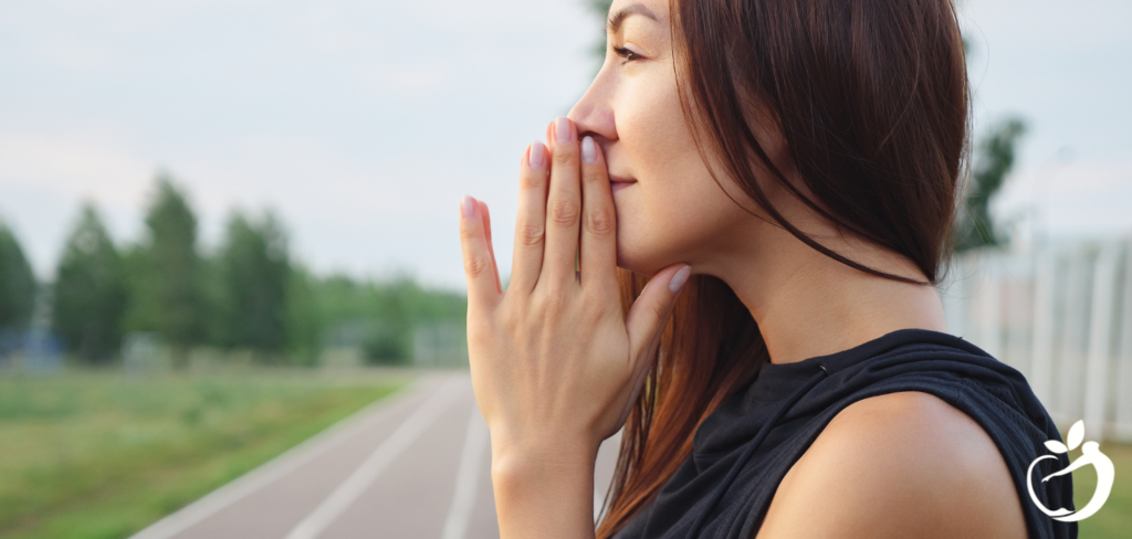 woman with folder hands held up to her mouth