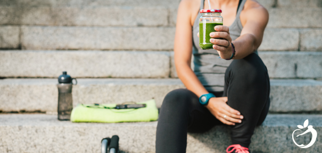 woman sitting on steps drinking a detox green smoothie