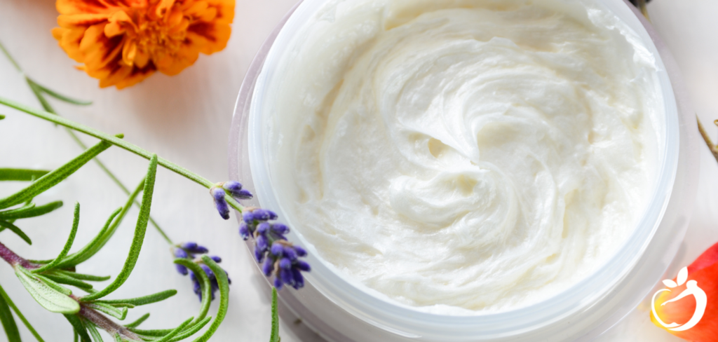 skin cream in a bowl with lavender and flowers around it