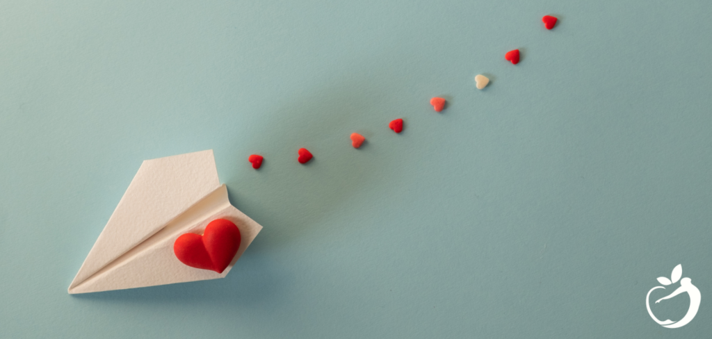 Blog Post Header Image - Healthy Valentine’s Day. Image of a paper airplane with hearts.