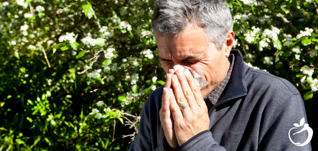 man blowing his nose outside