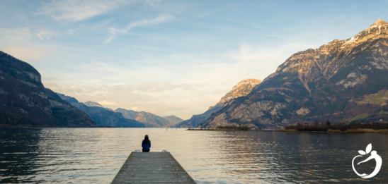 Meeting Your Health Goals: Our Top 5 “R” Resolutions - image of a person sitting at the end of a dock meditating.