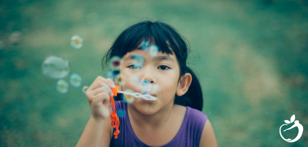 little girl blowing bubbles