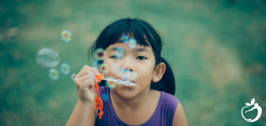 Image of little girl blowing bubbles