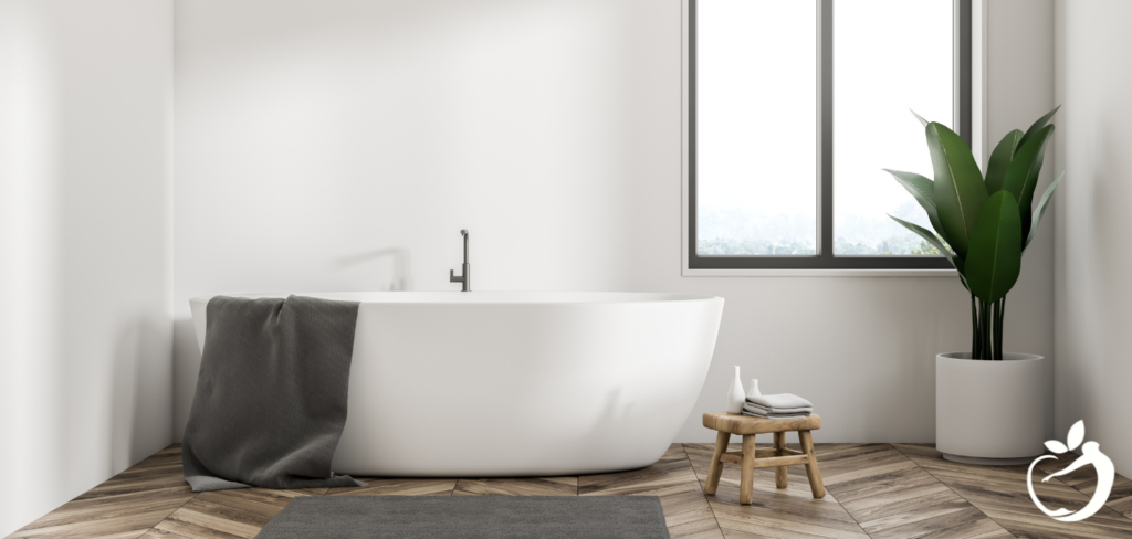 a clean, bright bathroom with a towel over the rim of the bathtub