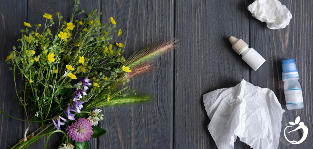 flowers, tissue, and allergy drops on a table