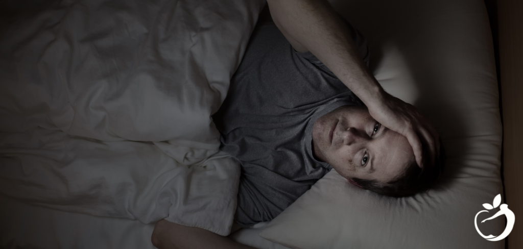 Blog Post Header Image - Tips for Improving Sleep. Man in bed staring up at the ceiling, not able to sleep.