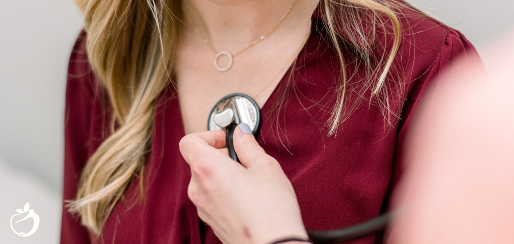 woman in a red dress getting checked out by a doctor