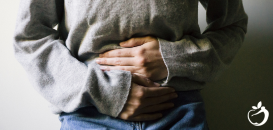 Image of person holding their stomach as it relates to pelvic dysfunction and pelvic floor therapy.