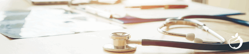 stethoscope on a table with papers