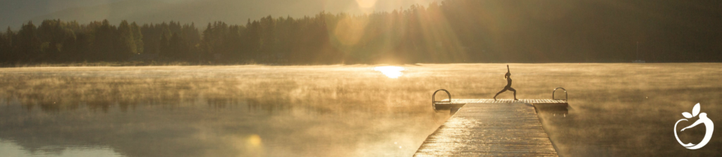 woman doing yoga at the end of a pier at sunrise