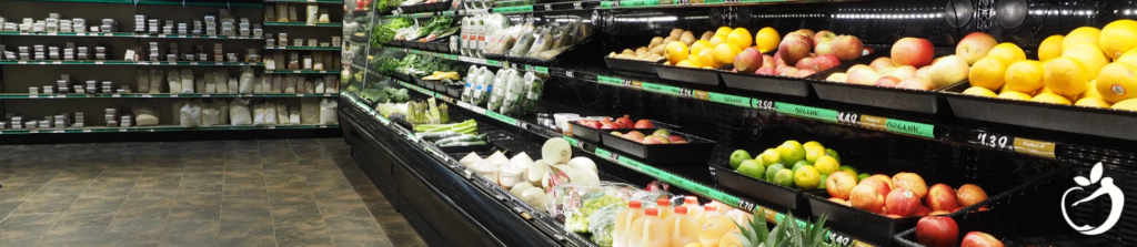 grocery store isle with fresh produce lining the wall