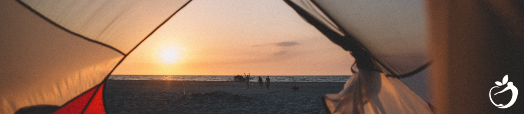 view of a beach and the ocean through the front entrance of a tent