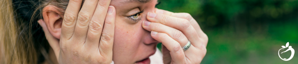 woman holding her nose, and head