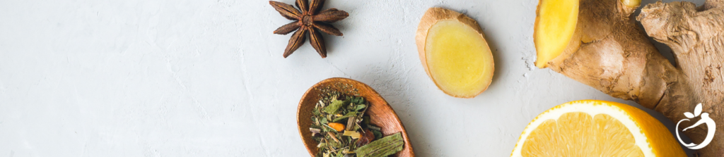 ginger, star anise, lemon and herbs in a bowl on a table