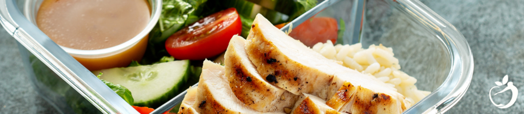 prepared meal of chicken and a vegetable salad in a container