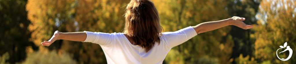 woman standing in the sun with her arms out