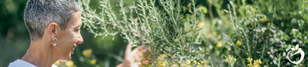 woman in the garden smile, picking herbs