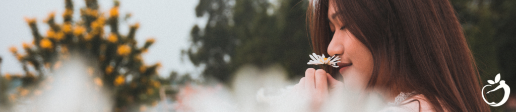 a woman smelling a flower outside