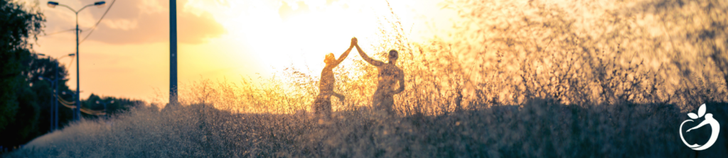 two people holding hands at sunset