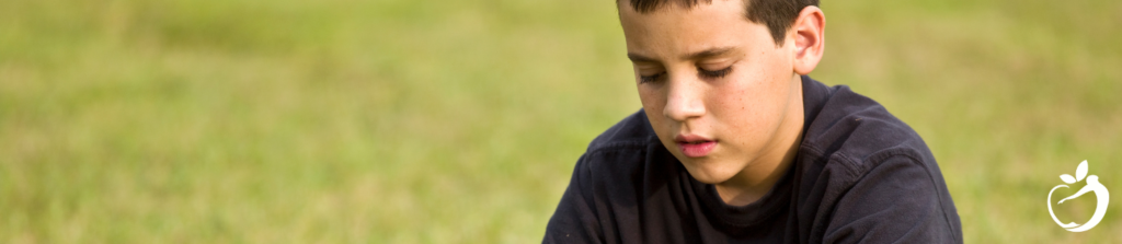 Inline Image 2 - PANS/PANDAS Risk Factors & Causes - image of young boy looking at grass, thinking about life