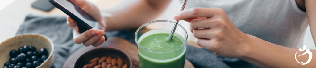 person drinking green smoothie, eating almonds, and blueberries