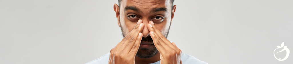 man holding his nose with both hands