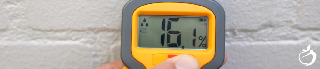 Image of a person holding a hygrometer, used to monitor humidity.