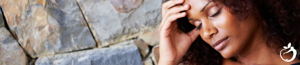 woman touching her forehead with her eyes closed