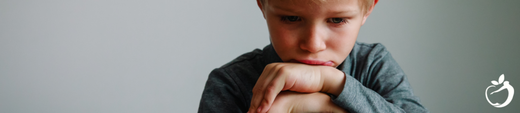 child frowning with his had resting on his hands