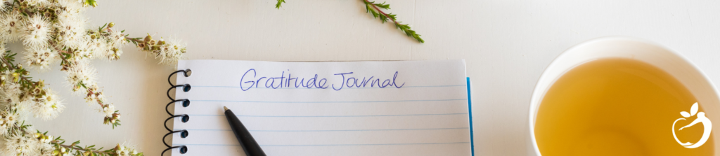 gratitude journal on a table with a cup of tea