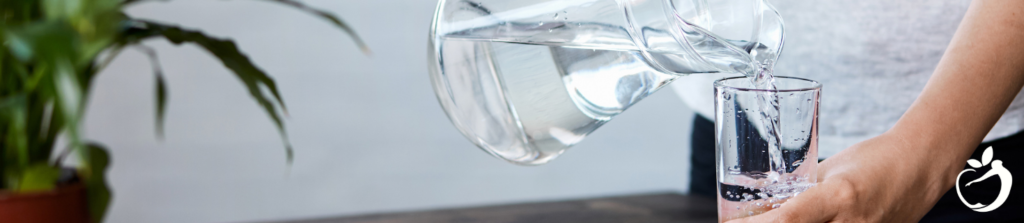 a person pouring a glass of water