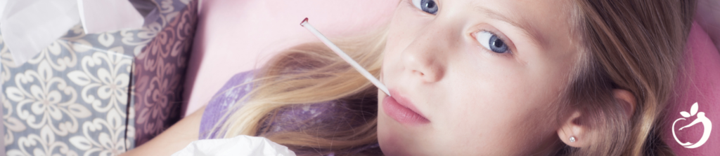 young child getting their temperature taken with a thermometer