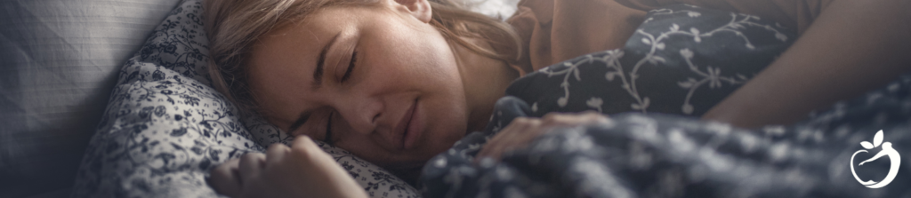 woman sleeping on her bed with her head on her pillow and blanket over her body