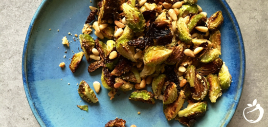 Recipe Post Header Image - Brussels Sprouts With Pine Nuts. Image of Brussels sprouts on a plate sprinkled with pine nuts.