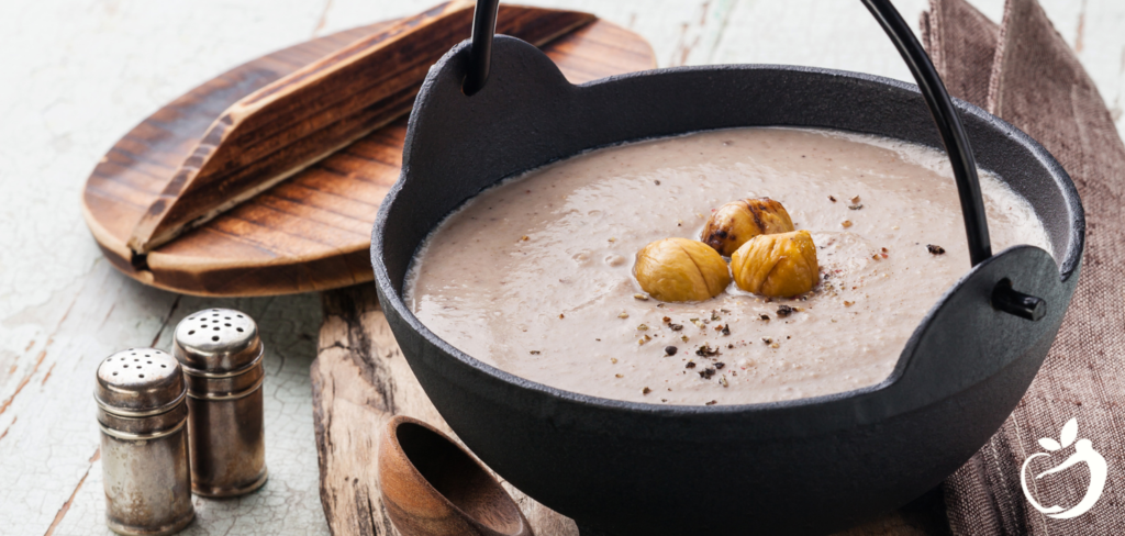 Recipe Post Header Image - Chestnut Soup With Cauliflower. Image of soup in a bowl garnished with roasted chestnuts.