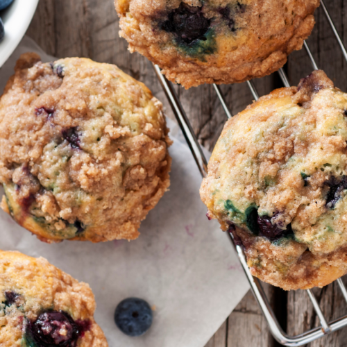 Recipe Post Header Image - Grain-Free Blueberry Muffins. Image of muffins on cooling rack.