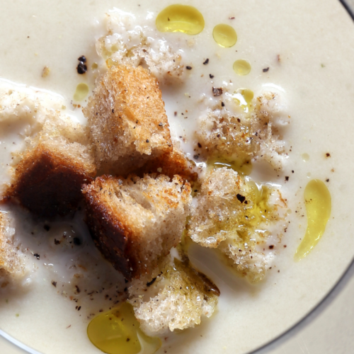 Recipe Post Header Image - Roasted Cauliflower Soup With Truffle Oil Drizzle. Image of soup in a bowl.