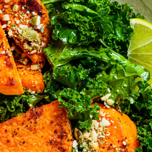 closeup of sweet potatoes, kale, and lime in a bowl