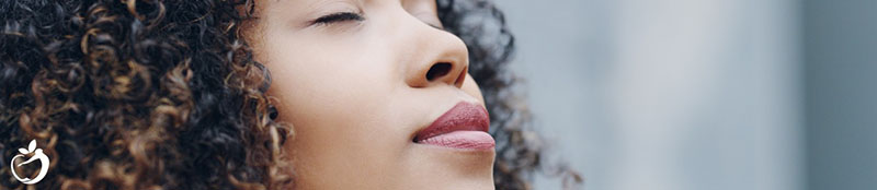 woman with her face turned up to the sky and her eyes closed