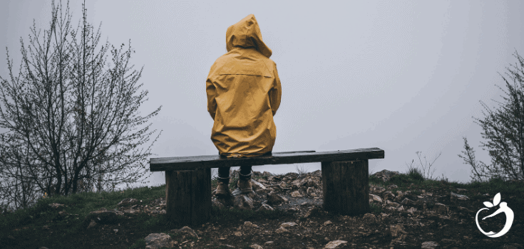 person sitting on a bench in yellow coat